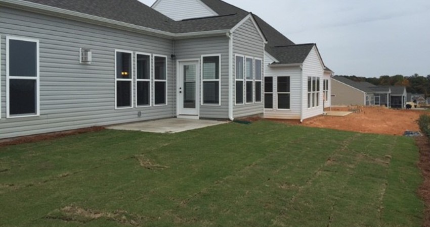 Backyard with basic builder installed concrete patio