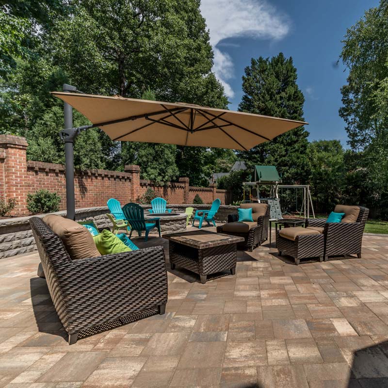 Backyard patio with fire pit and seating wall plus landscape plantings by Benton Outdoor Living