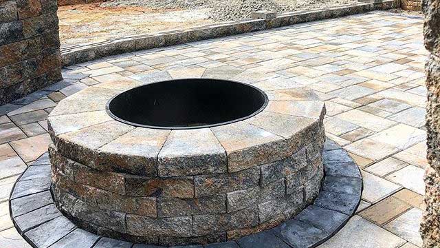 Fire pit built in still under construction patio in the Palisades neighborhood in Charlotte, NC by Benton Outdoor Living