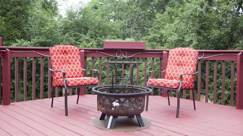 Fire pit sitting on a fire resistant mat on a wooden deck