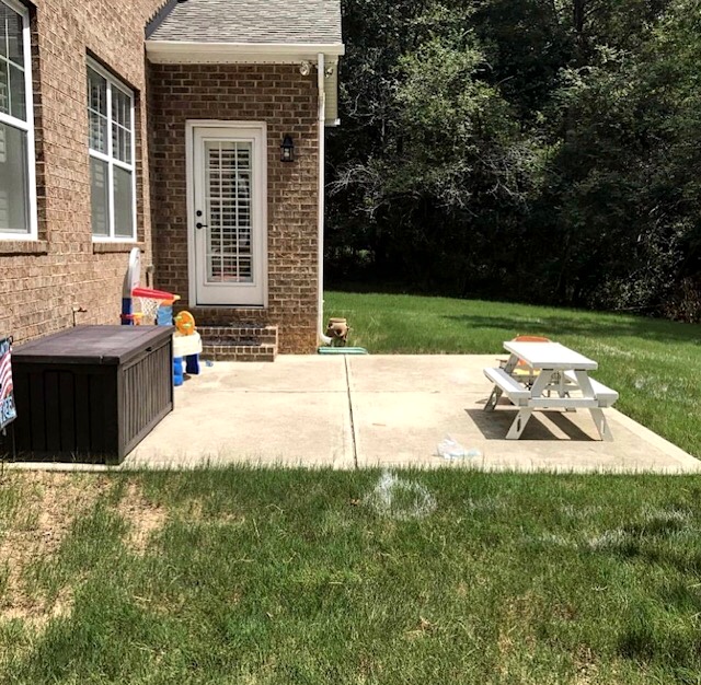 Before photo of a Charlotte backyard with a basic concrete patio.