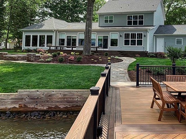 backyard on lakeafter Lake Wylie lake home yard transformation with new planting ares, paver walkway and improved dock by Benton Outdoor Living