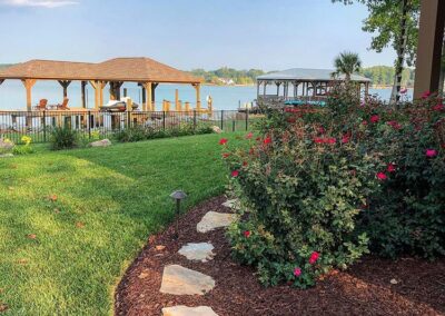 Lake Norman Landscaping with stones in the planting bed and bushes along the side of the house