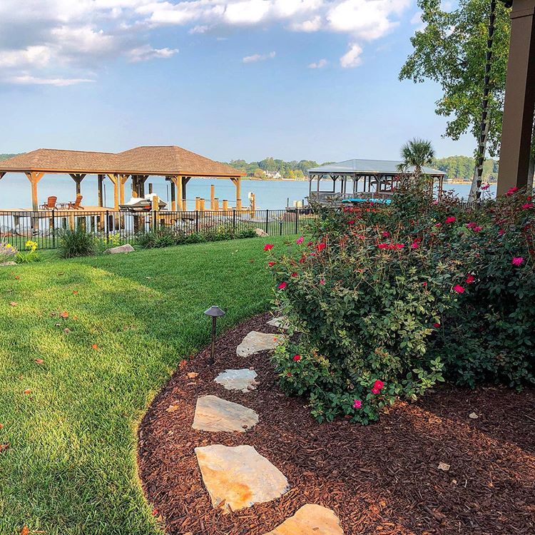 Lake Norman Landscaping with stones in the planting bed and bushes along the side of the house