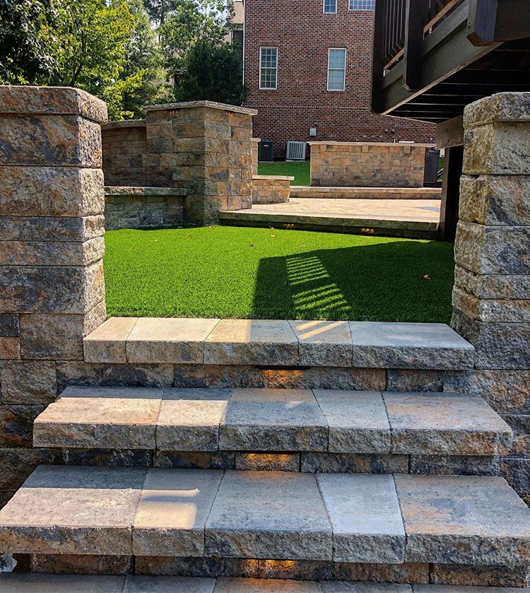 Paver walkways with a grassy area and walls to create a private garden area in a palisades, charlotte backyard
