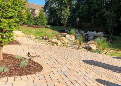 Backyard paver walkway, stairs and landscaping beds with rocks