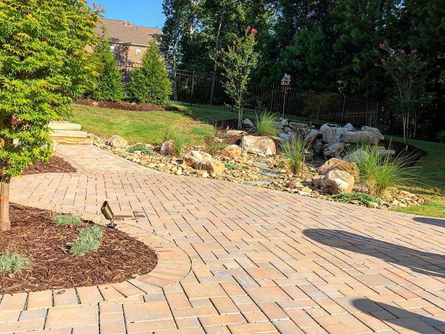 Backyard hardscape with paver walkway, stairs and landscaping beds with rocks