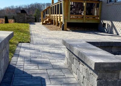 Waxhaw, NC backyard with deck paver walkway, fire pit, grill area and seating walls.