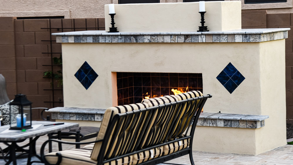 Outdoor fireplace with fire going on patio.