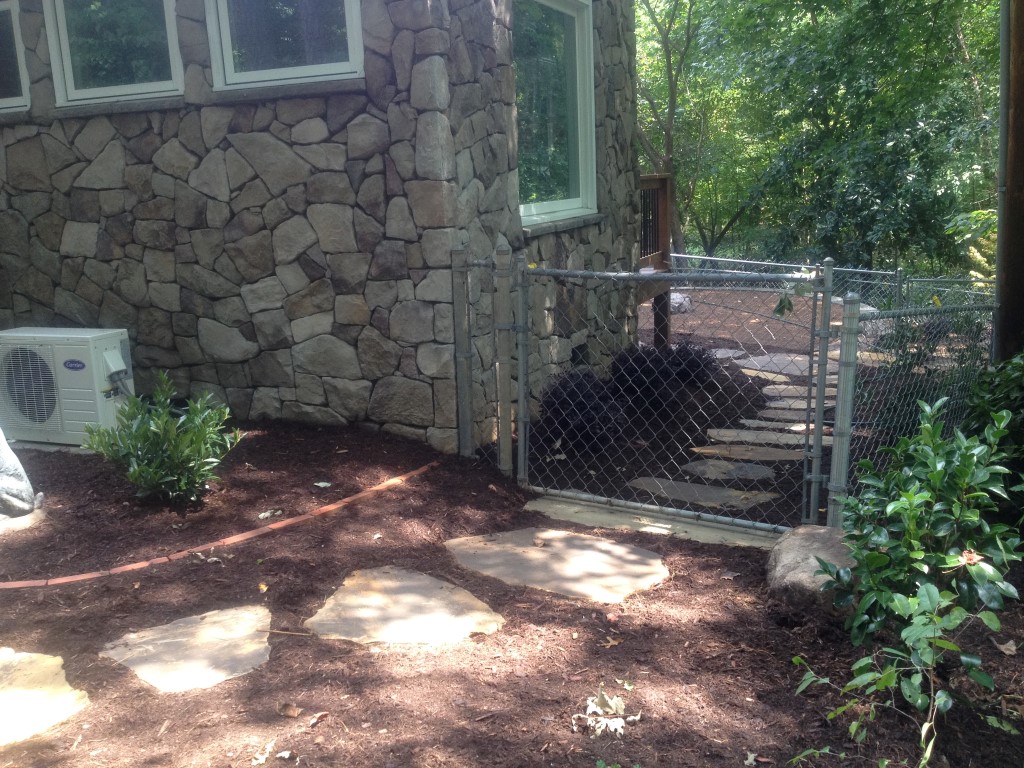 After photo of stepping stone and fence installed to help improve dog friendliness in a Charlotte area backyard.