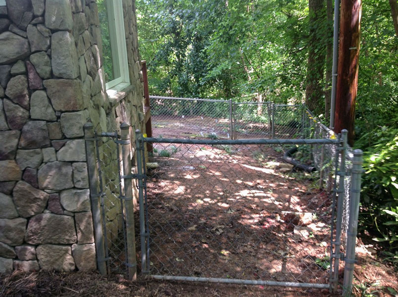 Side yard of dirt and mud after dogs walked around a lot in it.