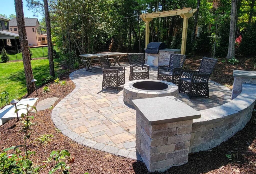 Waxhaw patio area in a wooded area of the yard with a curved shape and fire pit